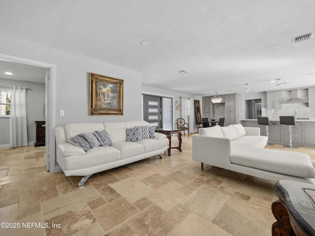 5062 N Ocean Shore Blvd, Palm Coast, FL 32137 - living room with stone tile floors, recessed lighting, and a textured ceiling