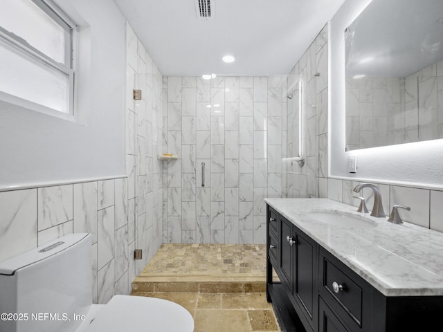 5062 N Ocean Shore Blvd, Palm Coast, FL 32137 - full bathroom featuring tile walls, vanity, a shower stall, recessed lighting, and stone finish floors