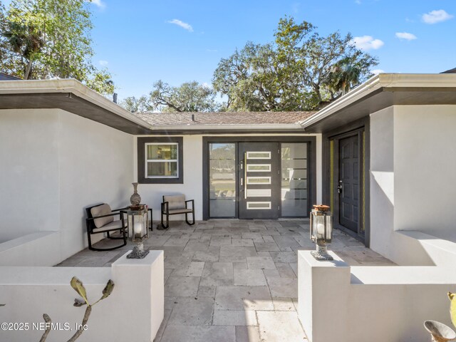5062 N Ocean Shore Blvd, Palm Coast, FL 32137 - view of exterior entry with stucco siding and a patio