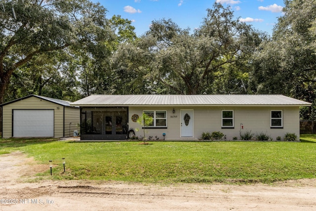 86759 Hester Dr, Yulee, FL 32097 - ranch-style house featuring a garage, a front lawn, an outdoor structure, a metal roof, and driveway