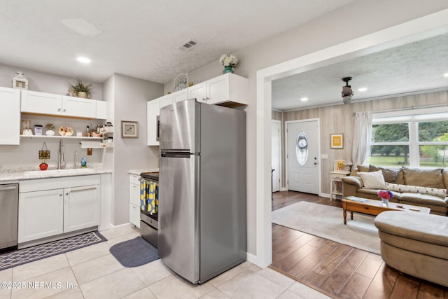 86759 Hester Dr, Yulee, FL 32097 - kitchen featuring stainless steel appliances, open floor plan, white cabinets, open shelves, and a textured ceiling