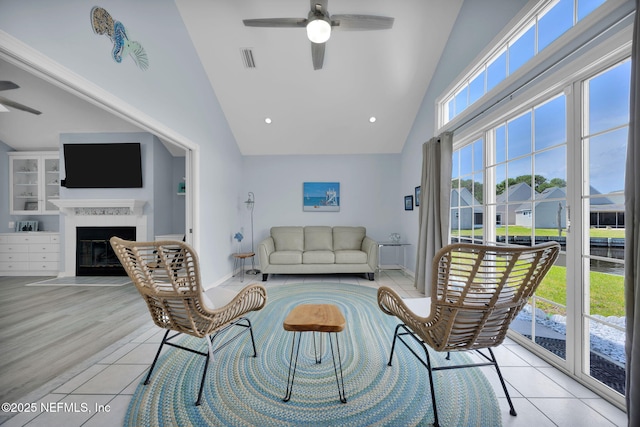 107 Hammock Cir, Saint Augustine, FL 32084 - living room featuring a ceiling fan, high vaulted ceiling, a fireplace with flush hearth, and light tile patterned floors