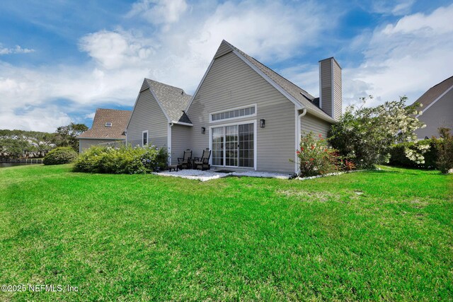 107 Hammock Cir, Saint Augustine, FL 32084 - back of house featuring a patio, a chimney, and a lawn