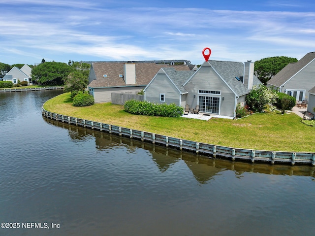 107 Hammock Cir, Saint Augustine, FL 32084 - back of house featuring a chimney, a water view, a lawn, and a shingled roof