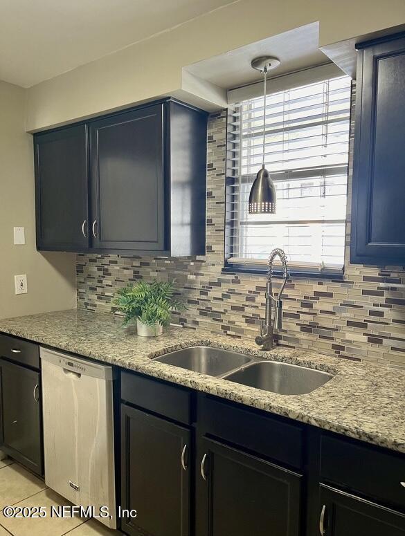 1713 El Camino Rd Unit 3, Jacksonville, FL 32216 - kitchen featuring stainless steel dishwasher, tasteful backsplash, light stone counters, and light tile patterned floors