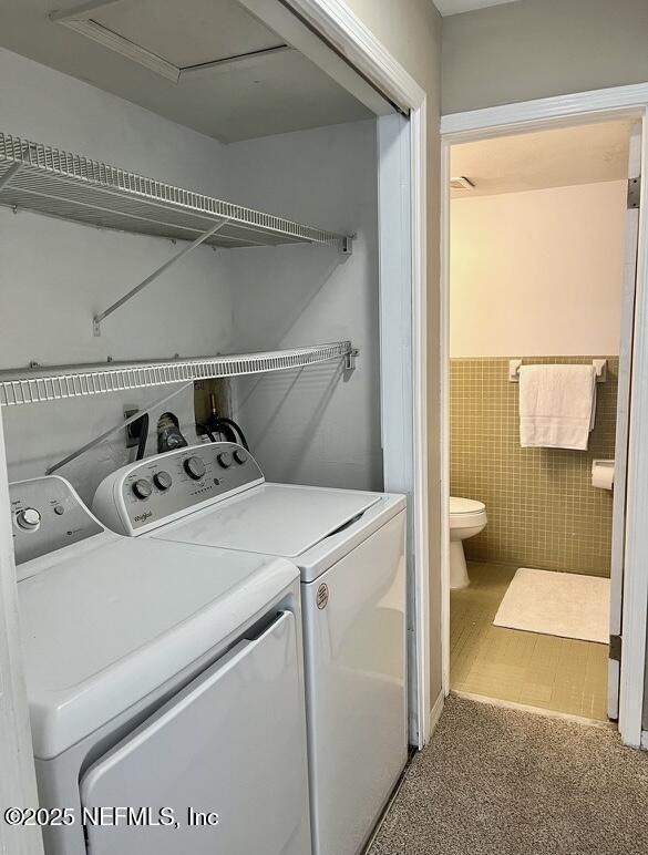 1713 El Camino Rd Unit 3, Jacksonville, FL 32216 - laundry area featuring independent washer and dryer, wainscoting, and tile walls