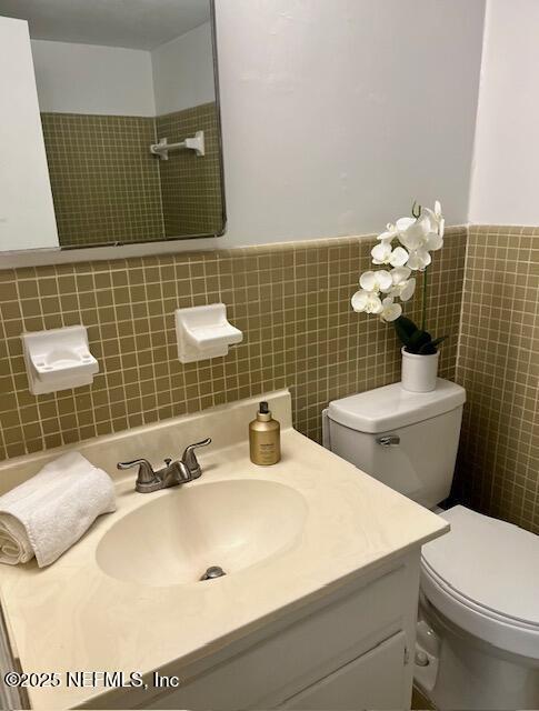 1713 El Camino Rd Unit 3, Jacksonville, FL 32216 - bathroom with vanity, tile walls, and a wainscoted wall