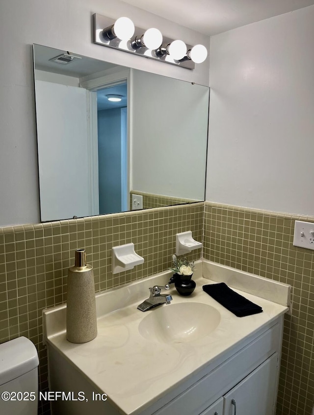 1713 El Camino Rd Unit 3, Jacksonville, FL 32216 - bathroom with vanity, tile walls, and a wainscoted wall