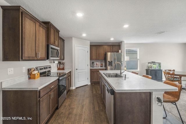 4433 Warm Springs Way, Middleburg, FL 32068 - kitchen featuring appliances with stainless steel finishes, light countertops, dark wood-style floors, a center island with sink, and recessed lighting