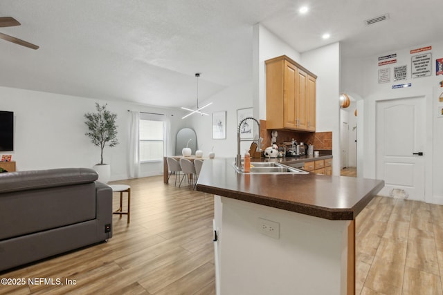 13967 Devan Lee Dr N, Jacksonville, FL 32226 - kitchen featuring a ceiling fan, open floor plan, dark countertops, light wood-style flooring, and backsplash