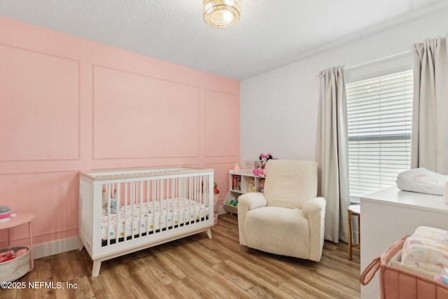 13967 Devan Lee Dr N, Jacksonville, FL 32226 - bedroom featuring a decorative wall, light wood finished floors, and a nursery area