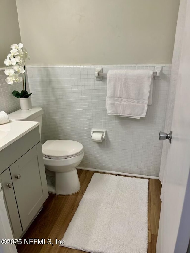1716 El Camino Rd Unit 3, Jacksonville, FL 32216 - half bath featuring tile walls, wood finished floors, vanity, and a wainscoted wall