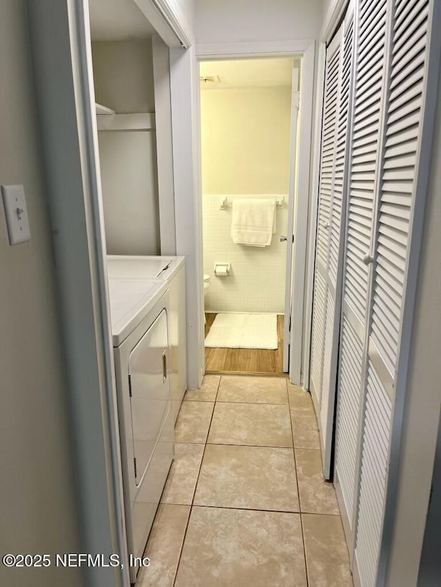 1716 El Camino Rd Unit 3, Jacksonville, FL 32216 - washroom featuring separate washer and dryer, light tile patterned floors, and tile walls