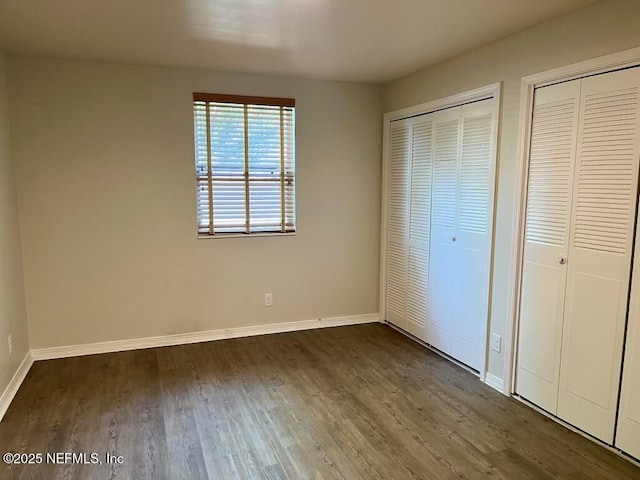 1716 El Camino Rd Unit 3, Jacksonville, FL 32216 - unfurnished bedroom featuring dark wood-style flooring and multiple closets