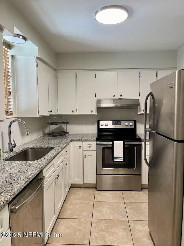 1716 El Camino Rd Unit 3, Jacksonville, FL 32216 - kitchen featuring stainless steel appliances, under cabinet range hood, white cabinets, and light stone countertops