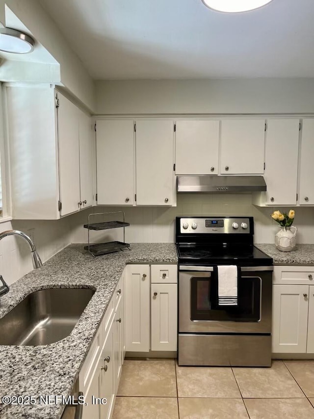 1716 El Camino Rd Unit 3, Jacksonville, FL 32216 - kitchen featuring stainless steel electric stove, under cabinet range hood, white cabinetry, light tile patterned floors, and light stone counters