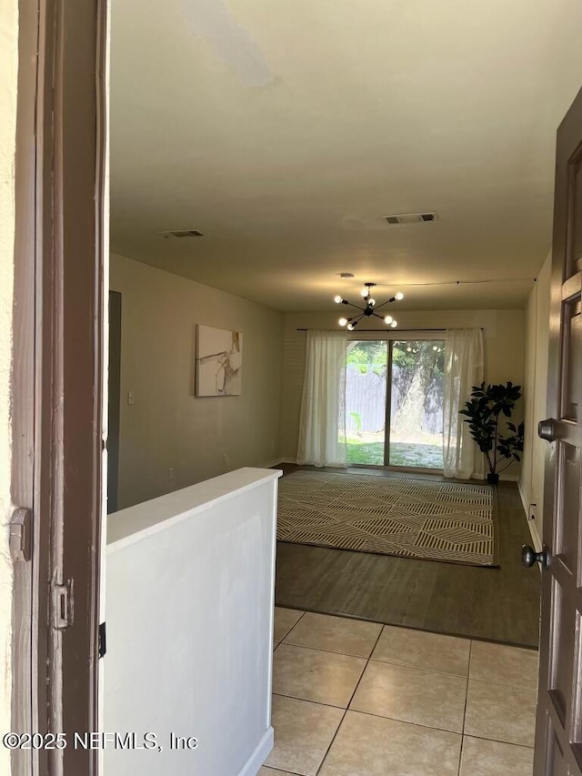 1716 El Camino Rd Unit 3, Jacksonville, FL 32216 - hall with light tile patterned flooring and a chandelier