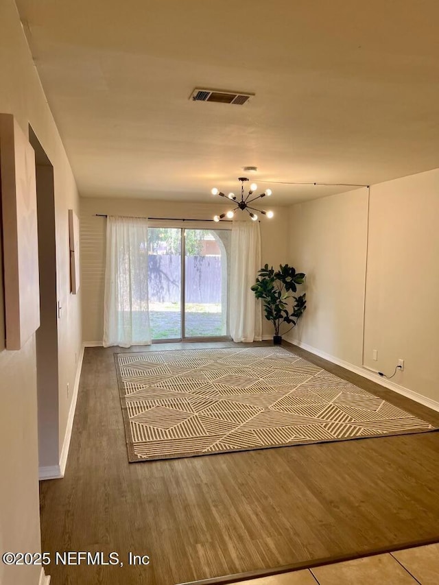 1716 El Camino Rd Unit 3, Jacksonville, FL 32216 - empty room featuring a chandelier and wood finished floors