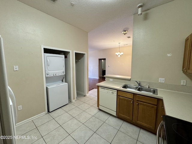 9626 Belda Way Unit 7, Jacksonville, FL 32257 - kitchen featuring dishwasher, stacked washer and clothes dryer, brown cabinets, electric range, and light tile patterned flooring