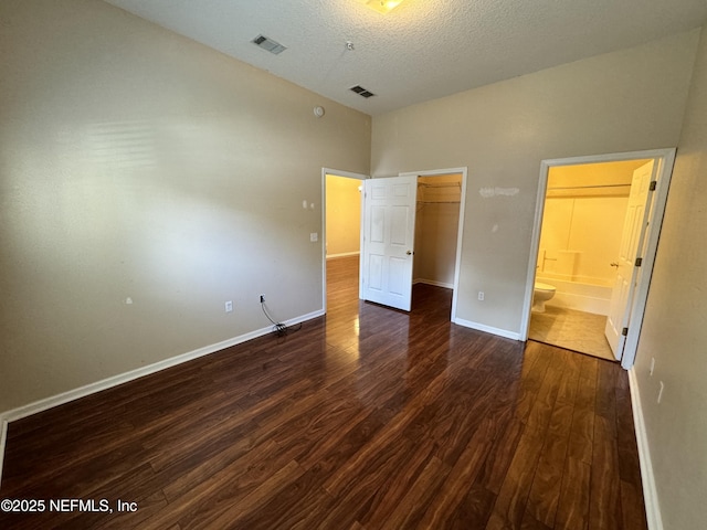 9626 Belda Way Unit 7, Jacksonville, FL 32257 - unfurnished bedroom with wood finished floors, a closet, a spacious closet, ensuite bathroom, and a textured ceiling