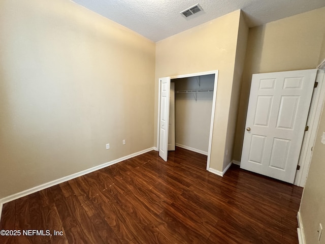 9626 Belda Way Unit 7, Jacksonville, FL 32257 - unfurnished bedroom with dark wood-style floors, a closet, and a textured ceiling