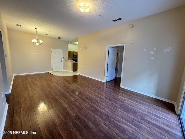 9626 Belda Way Unit 7, Jacksonville, FL 32257 - unfurnished living room featuring a chandelier, a textured ceiling, and dark wood finished floors