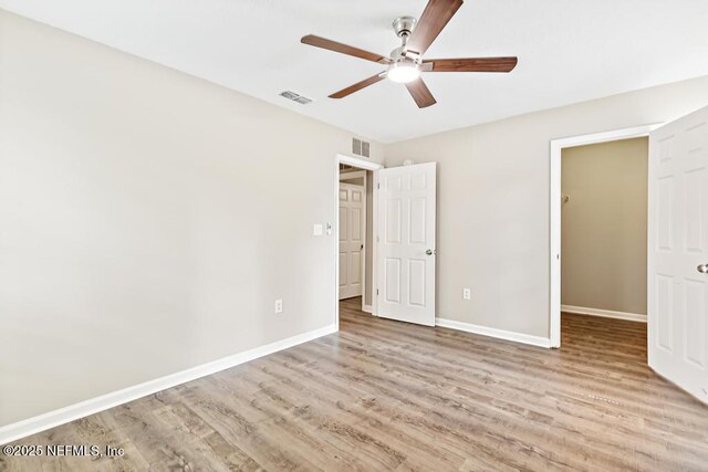 5522 Paris Ave, Jacksonville, FL 32209 - unfurnished bedroom with wood finished floors, a ceiling fan, and a spacious closet