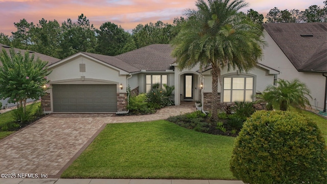 435 Tree Side Ln, Ponte Vedra, FL 32081 - view of front of house featuring stucco siding, an attached garage, decorative driveway, a yard, and stone siding