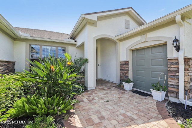 435 Tree Side Ln, Ponte Vedra, FL 32081 - view of exterior entry featuring stucco siding, stone siding, and a garage