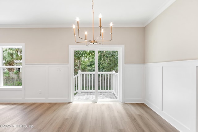 6334 Salado Rd, Saint Augustine, FL 32080 - unfurnished dining area featuring a decorative wall, a chandelier, crown molding, light wood-style floors, and wainscoting