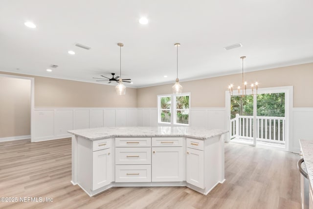 6334 Salado Rd, Saint Augustine, FL 32080 - kitchen featuring a ceiling fan, wainscoting, a chandelier, a kitchen island, and light wood finished floors