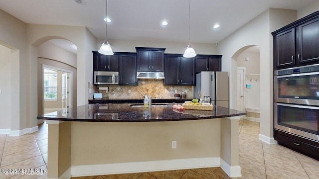 1911 Salt Creek Dr, Fleming Island, FL 32003 - kitchen with appliances with stainless steel finishes, dark stone countertops, backsplash, light tile patterned flooring, and recessed lighting