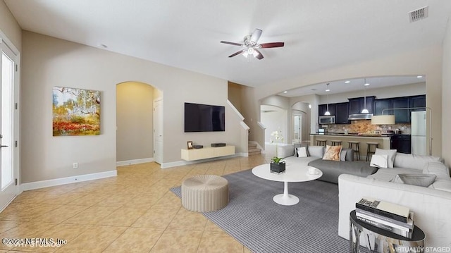 1911 Salt Creek Dr, Fleming Island, FL 32003 - living area with arched walkways, a ceiling fan, light tile patterned floors, and stairway