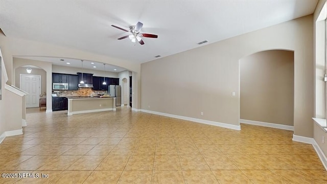 1911 Salt Creek Dr, Fleming Island, FL 32003 - unfurnished living room featuring arched walkways, ceiling fan, light tile patterned floors, and recessed lighting