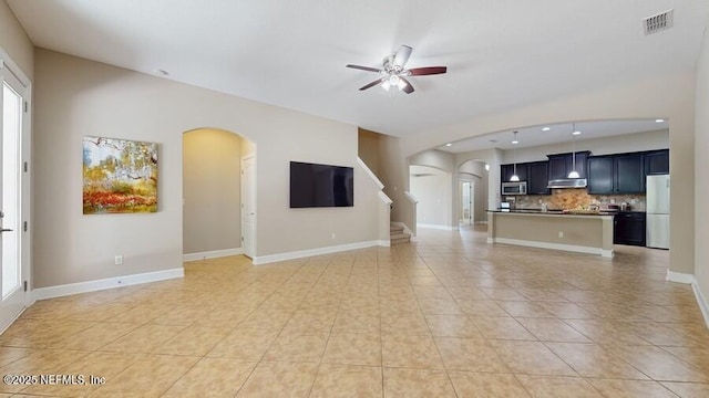 1911 Salt Creek Dr, Fleming Island, FL 32003 - unfurnished living room with arched walkways, ceiling fan, light tile patterned flooring, stairway, and recessed lighting