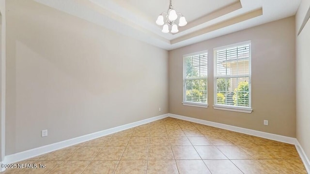 1911 Salt Creek Dr, Fleming Island, FL 32003 - spare room featuring a chandelier, light tile patterned flooring, and a tray ceiling