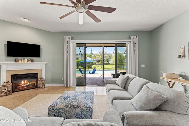 33114 Prairie Parke Pl, Fernandina Beach, FL 32034 - living area featuring ceiling fan, tile patterned flooring, a premium fireplace, and a textured ceiling
