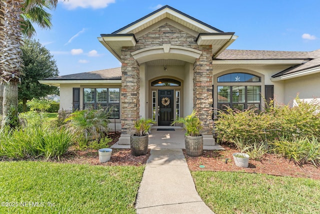 33114 Prairie Parke Pl, Fernandina Beach, FL 32034 - doorway to property with stucco siding, stone siding, and a shingled roof