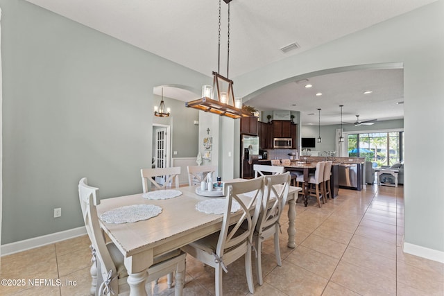 33114 Prairie Parke Pl, Fernandina Beach, FL 32034 - dining room with arched walkways, recessed lighting, light tile patterned floors, and a chandelier