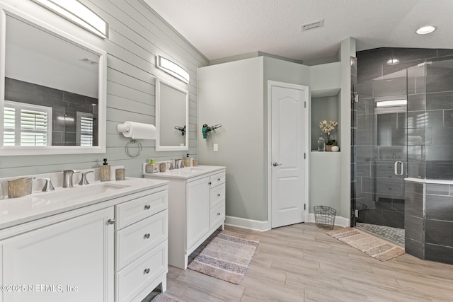 33114 Prairie Parke Pl, Fernandina Beach, FL 32034 - full bath with a shower stall, two vanities, wood finished floors, a textured ceiling, and recessed lighting