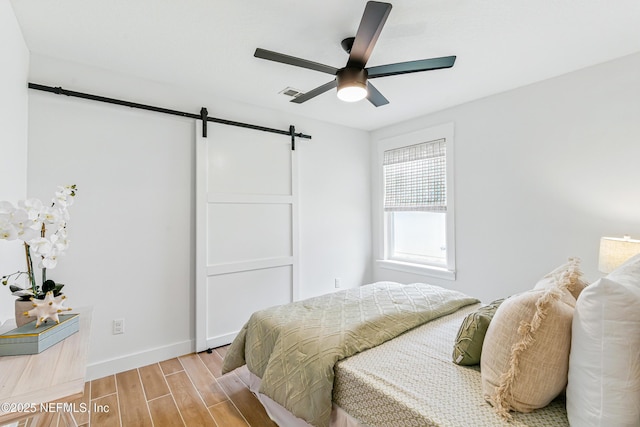 141 Balmoral Castle Dr, Saint Johns, FL 32259 - bedroom featuring a barn door, light wood-style flooring, and a ceiling fan