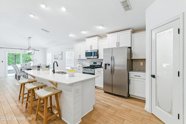 141 Balmoral Castle Dr, Saint Johns, FL 32259 - kitchen with appliances with stainless steel finishes, backsplash, light wood-type flooring, a breakfast bar area, and recessed lighting