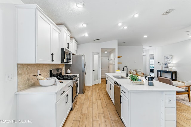 141 Balmoral Castle Dr, Saint Johns, FL 32259 - kitchen featuring appliances with stainless steel finishes, white cabinets, light wood-style flooring, tasteful backsplash, and light countertops