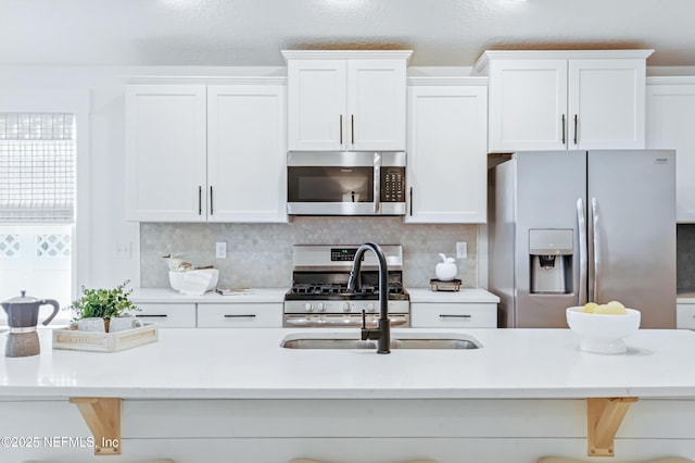 141 Balmoral Castle Dr, Saint Johns, FL 32259 - kitchen with stainless steel appliances, a kitchen breakfast bar, white cabinetry, light countertops, and decorative backsplash