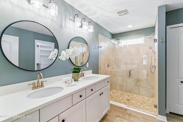 141 Balmoral Castle Dr, Saint Johns, FL 32259 - bathroom with a shower stall, double vanity, a textured ceiling, and wood finish floors
