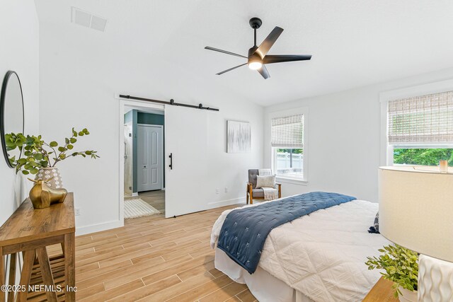 141 Balmoral Castle Dr, Saint Johns, FL 32259 - bedroom featuring a barn door, multiple windows, vaulted ceiling, and light wood-type flooring