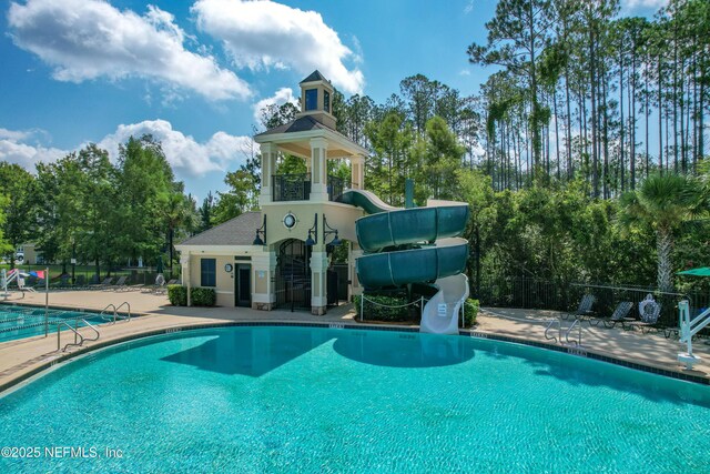 141 Balmoral Castle Dr, Saint Johns, FL 32259 - community pool with a patio area, a water slide, and view of scattered trees