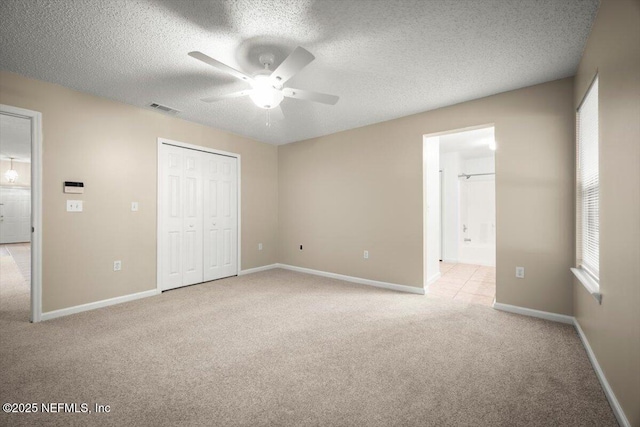 268 Southlake Dr, Saint Augustine, FL 32092 - unfurnished bedroom with light colored carpet, a textured ceiling, a closet, connected bathroom, and a ceiling fan