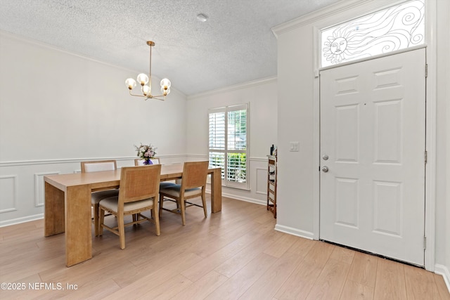1578 Linkside Dr, Atlantic Beach, FL 32233 - dining area featuring ornamental molding, a textured ceiling, a chandelier, wainscoting, and light wood-type flooring