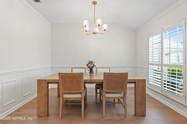 1578 Linkside Dr, Atlantic Beach, FL 32233 - dining space with a chandelier, crown molding, vaulted ceiling, a textured ceiling, and wainscoting
